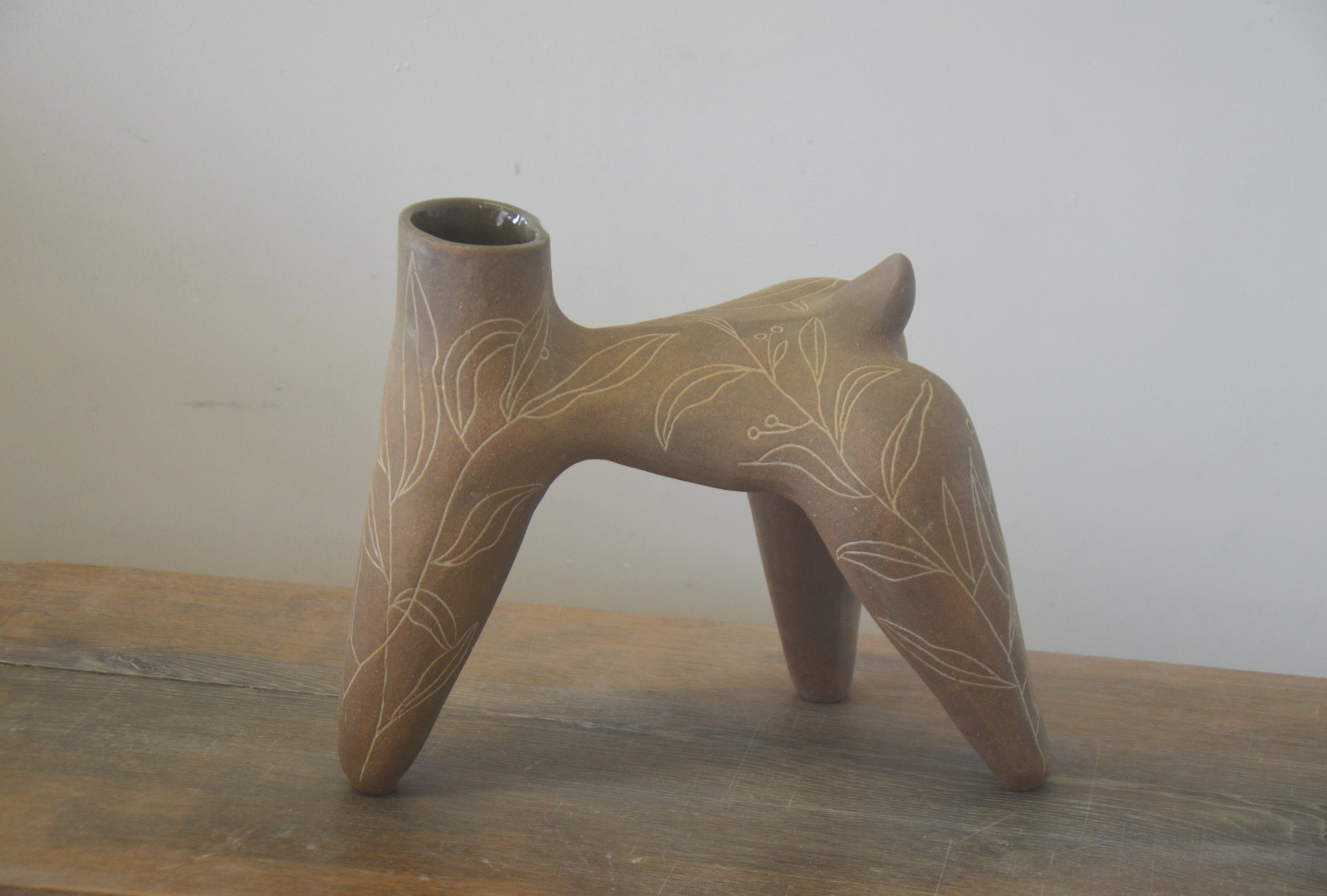 La même pièce de l'autre côté, sur une table en bois, le col ouvert à gauche.