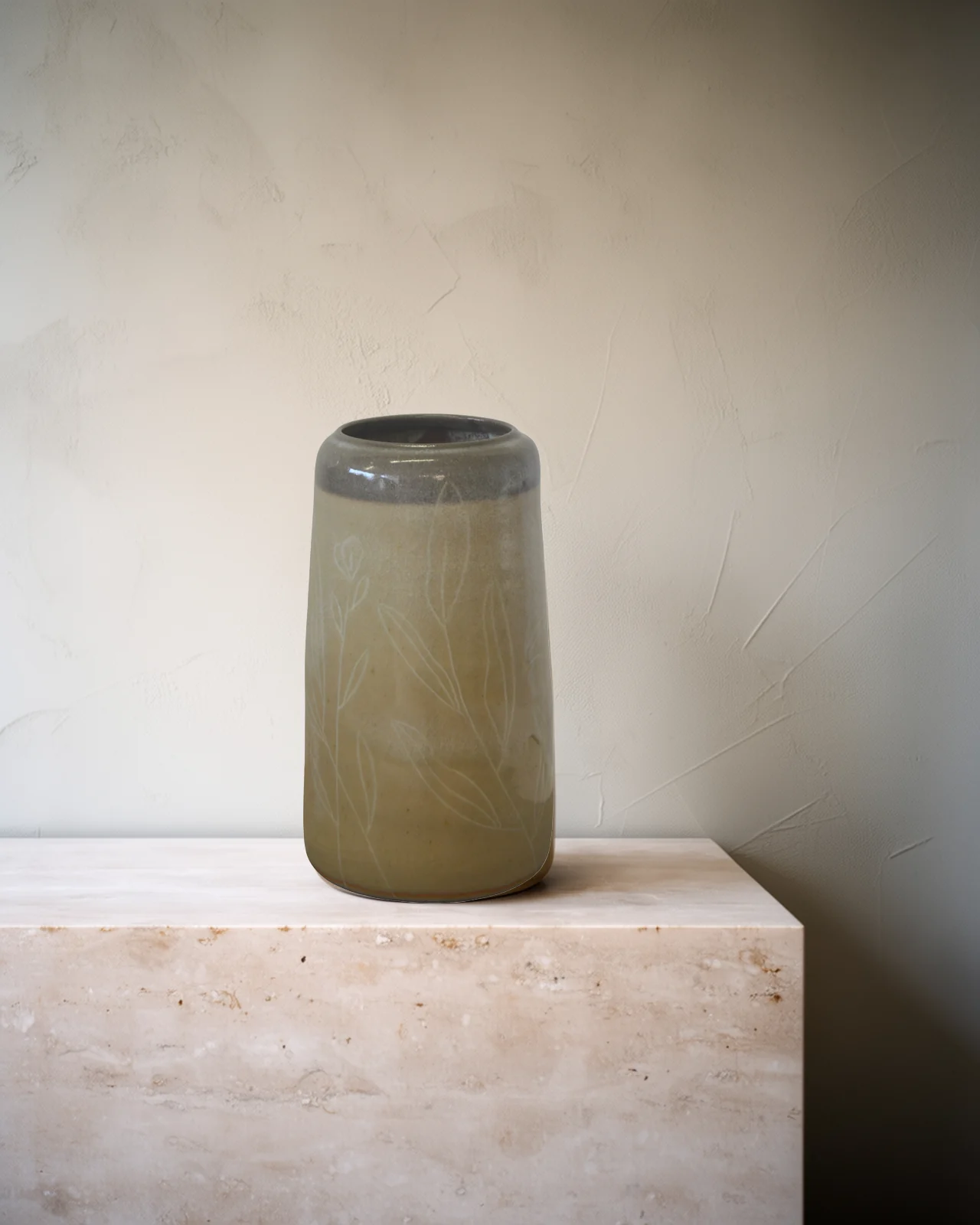 Vase en grès à l'émail sable, col gris, gravé de feuillages, sur un socle de travertin pâle.