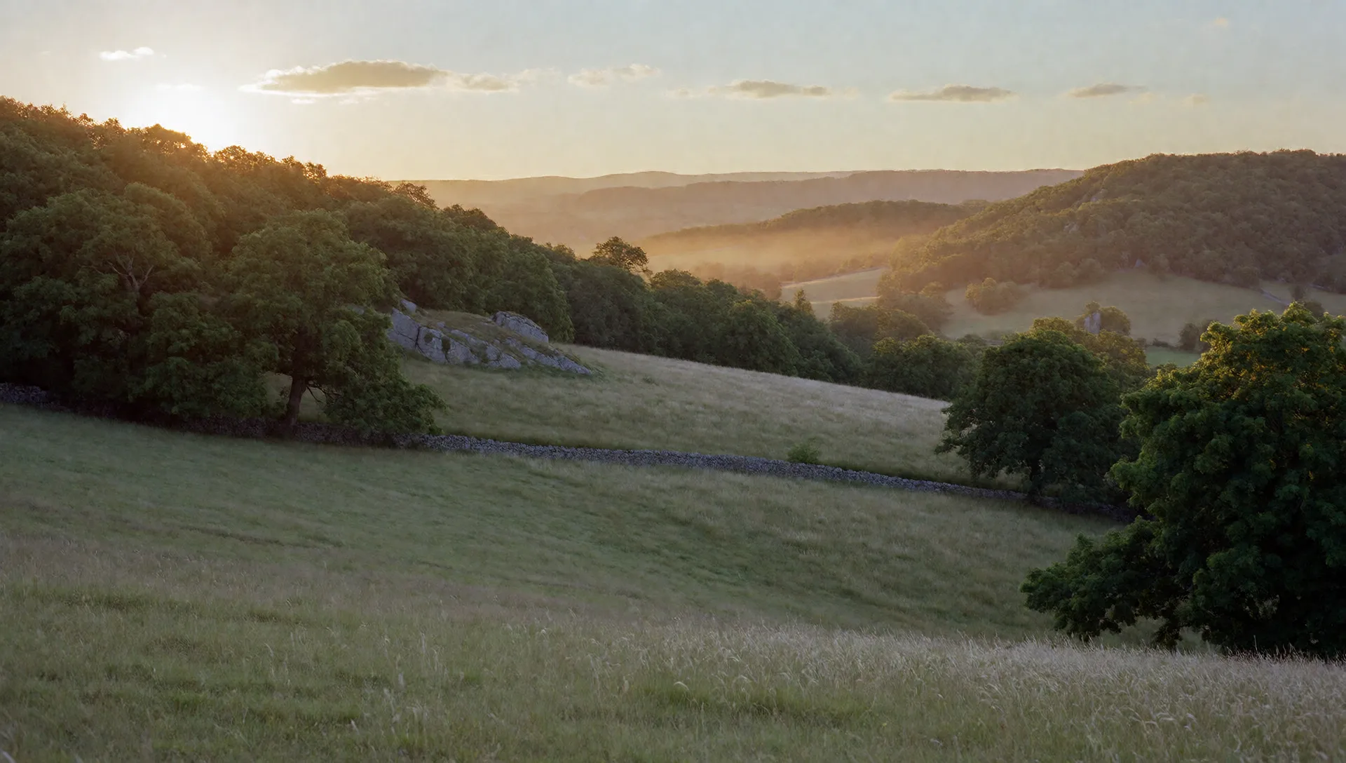 Une vallée du Limousin au soleil couchant, murets de pierre sèche, rochers de granit et chênes